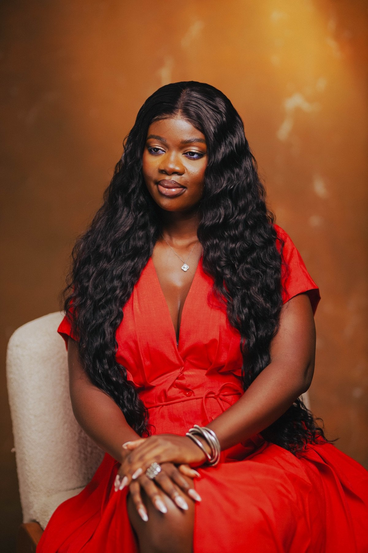 Mansa in a red dress, seated