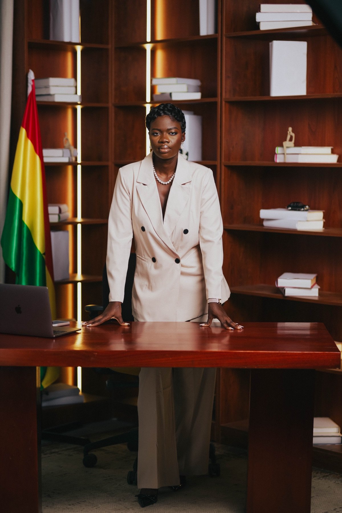 Mansa standing at her desk beside the Ghana flag