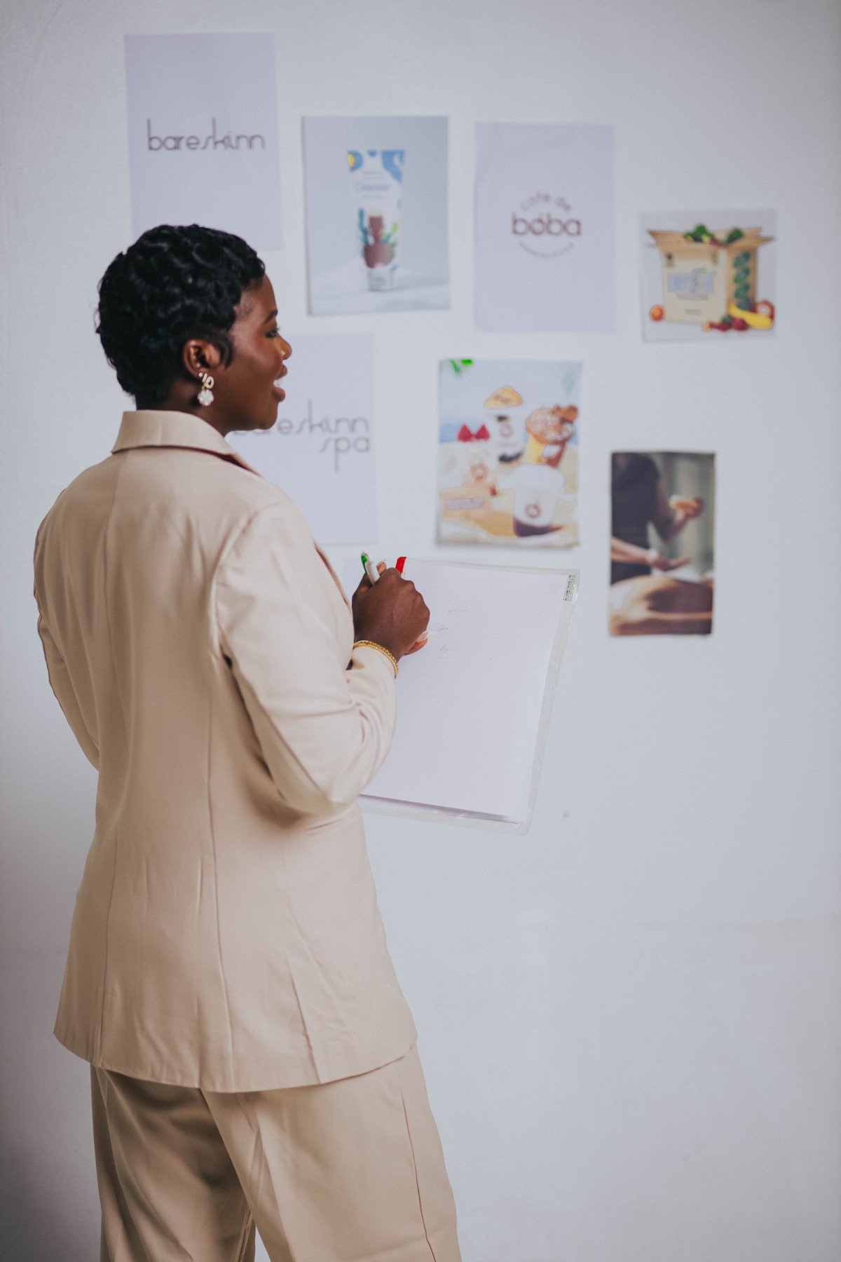 Mansa planning at a wall of her brand designs
